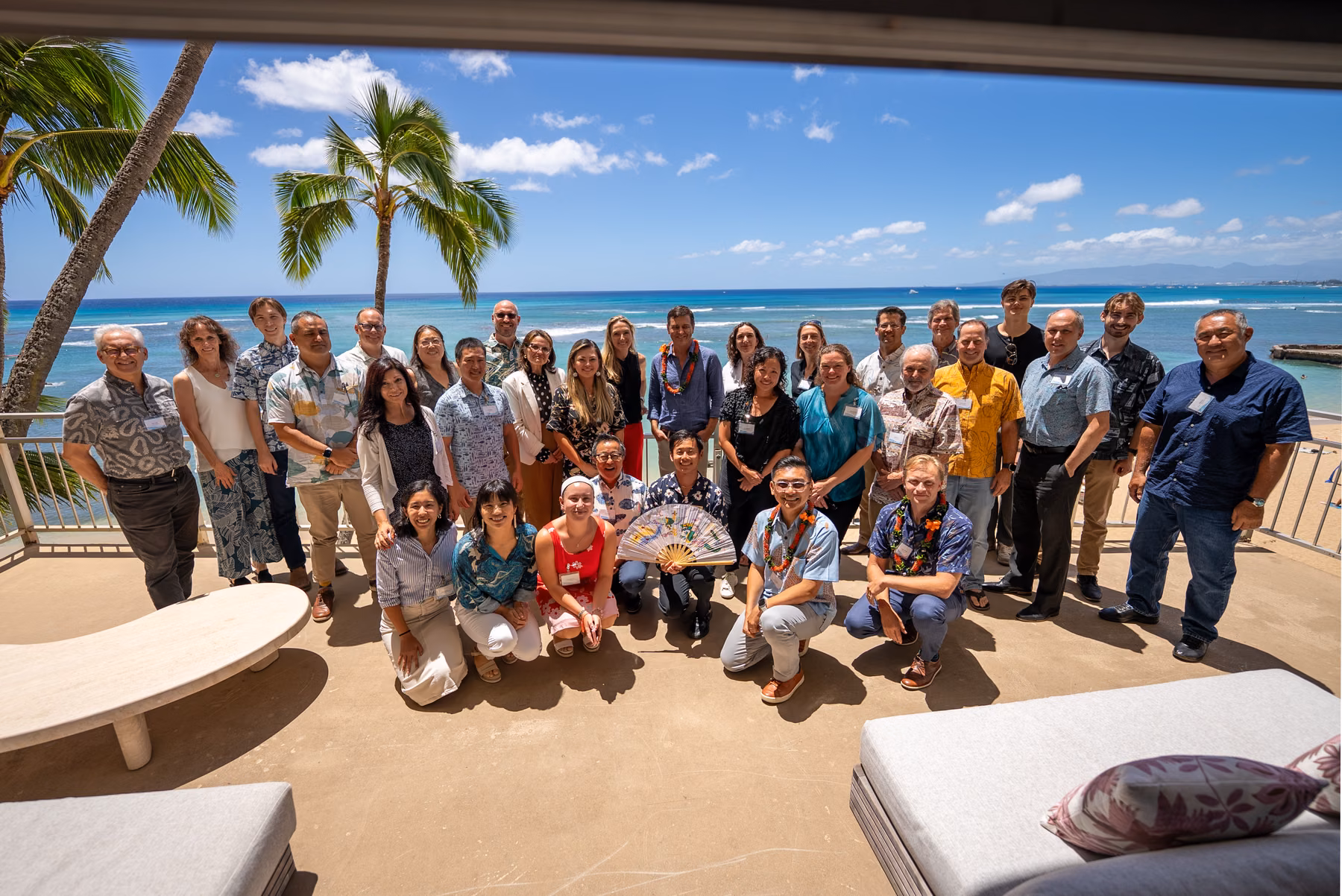 Participants gather outdoors by the ocean at the HTDC Blue Economy Luncheon.