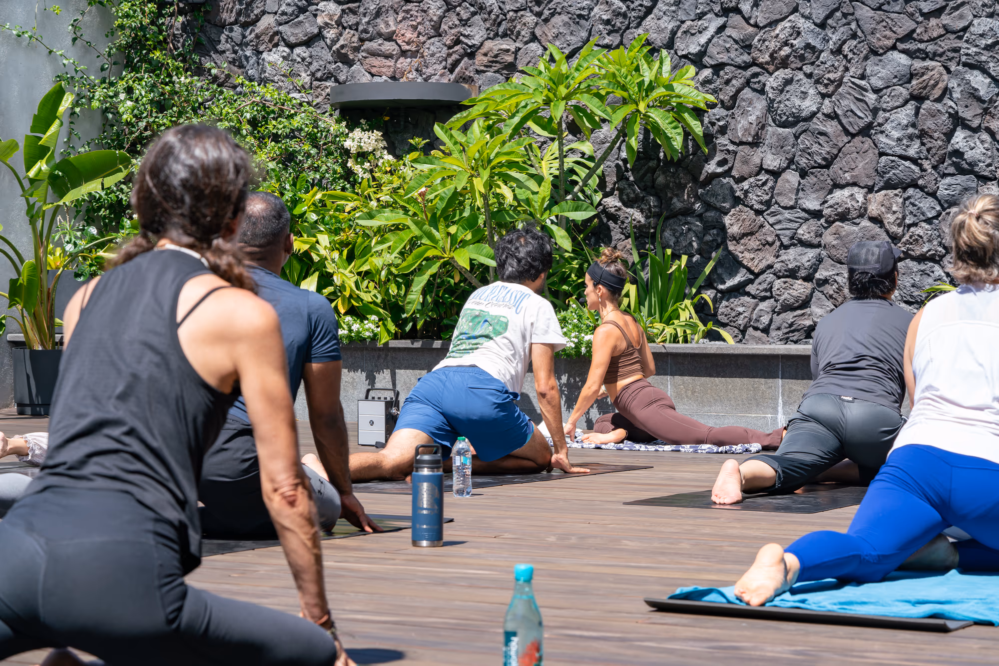 Participants practice yoga on mats in an outdoor courtyard.