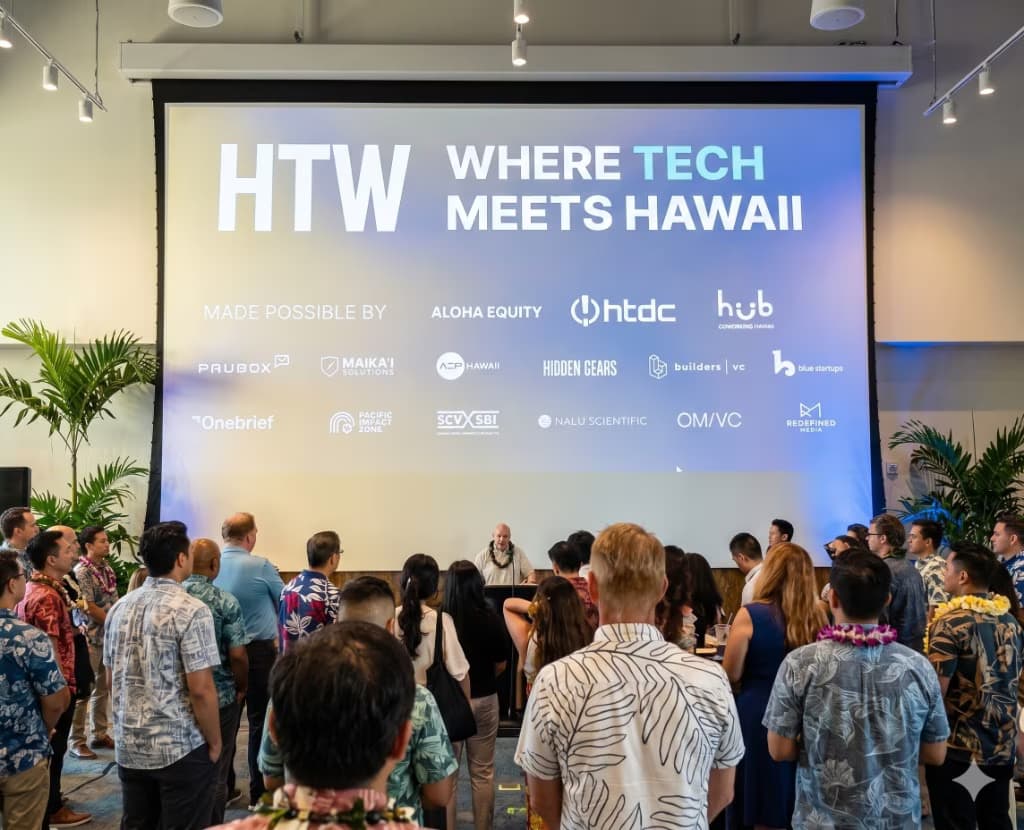 Packed anchor event crowd in front of the HTW "Where Tech Meets Hawaii" sponsor wall with all 15+ sponsor logos projected